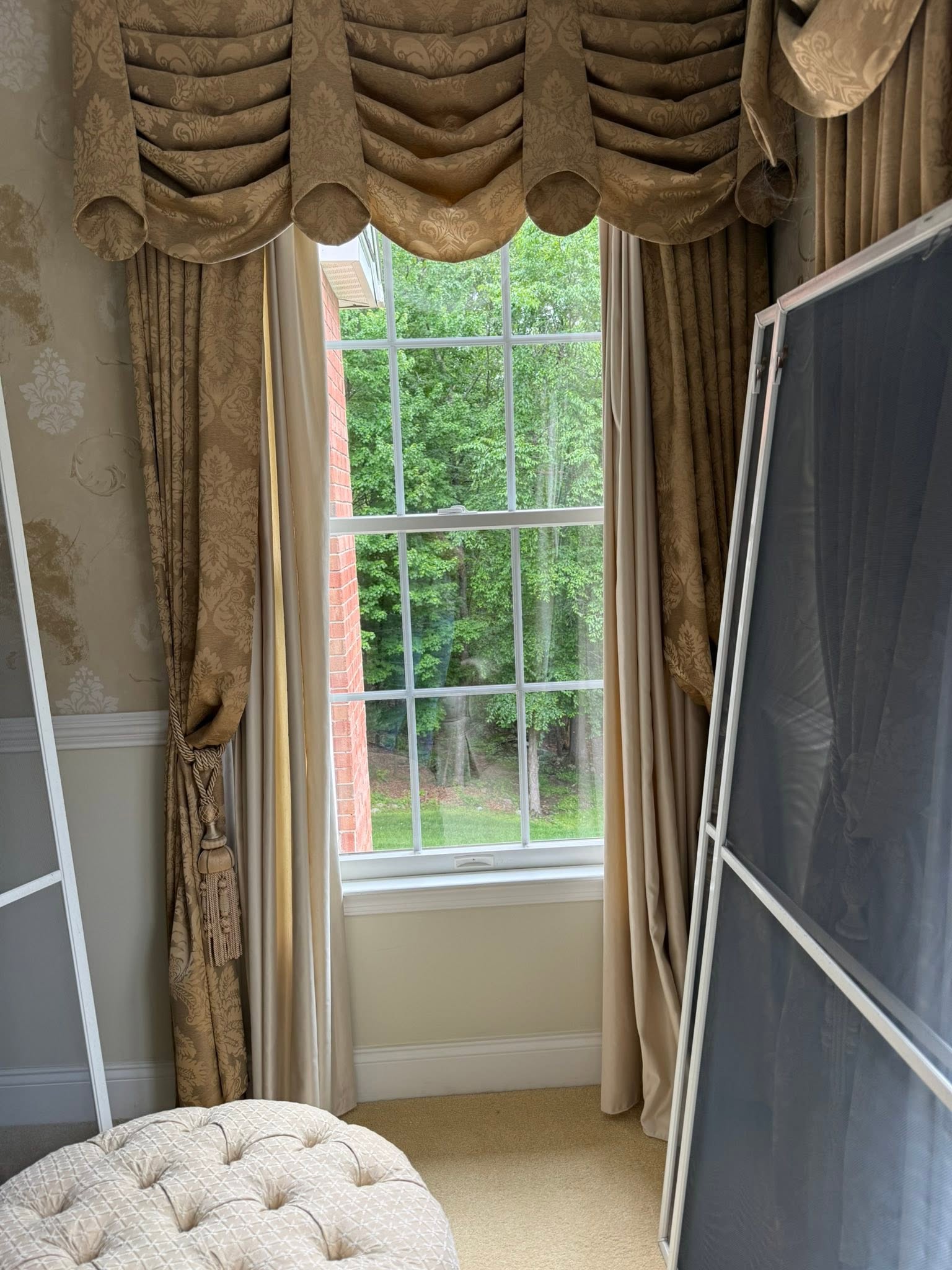 The same tall window after cleaning, clear view of green trees